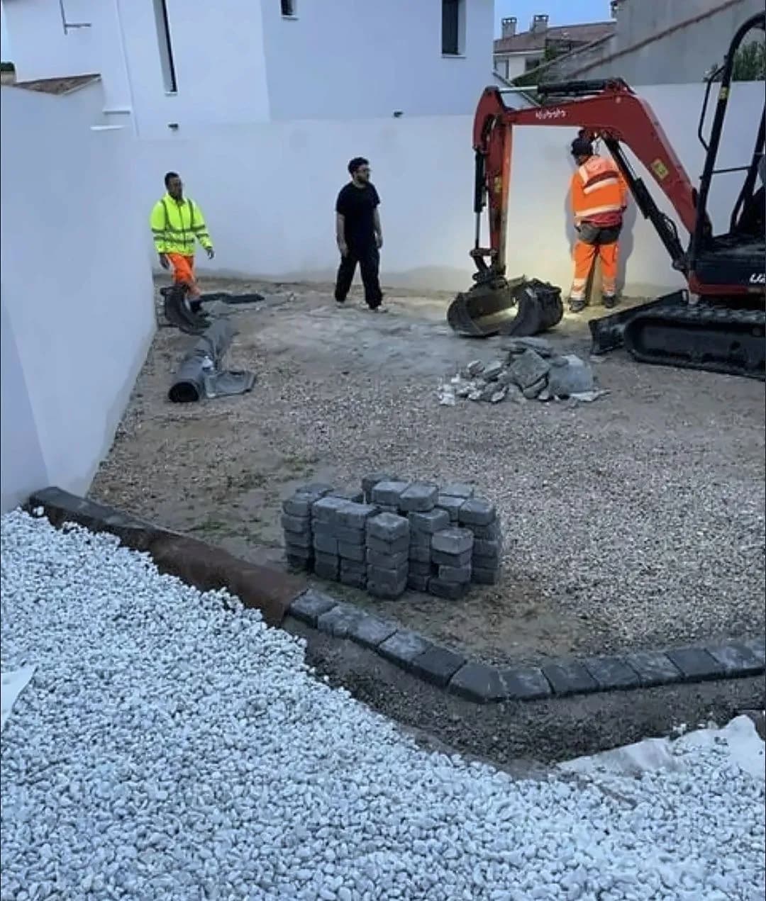 Cour en cours de terrassement par Bouthors Couverture : mini-pelle, gravier, bordures et palette de pavés